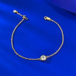 Vue détaillée d'un bracelet en argent S925 doré avec une pierre blanche ronde sertie clos