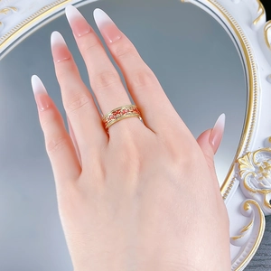 Detail of a vintage gold ring with red enamel floral patterns and a small center diamond