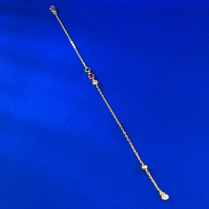 Bracelet doré élégant avec pierres précieuses vertes, rouges et claires sur fond bleu