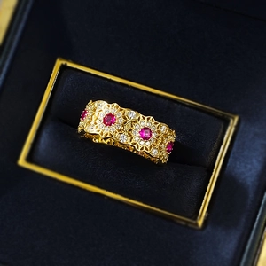Exquisite S925 gold vintage hollow flower ring with red diamonds on dark velvet
