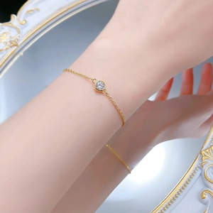 Détail d'un bracelet en argent S925 doré avec un zircon de 6mm porté au poignet