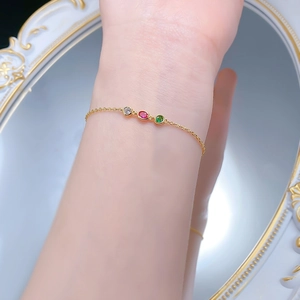 Détail du bracelet doré orné de zircons cubiques blancs rouges et verts sertis