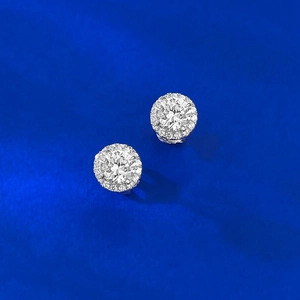 Macro shot of silver circular stud earrings with brilliant zircon halo in classic design