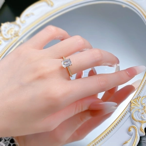 Detailed macro view showing the emerald-cut gem ring reflected in a white vintage mirror