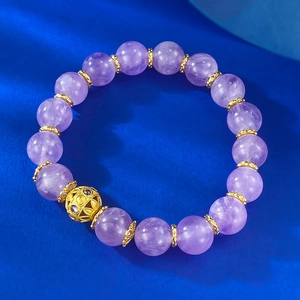 Elegant 10mm lavender amethyst bracelet with gold hollow accents on blue velvet