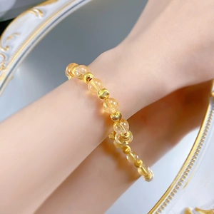 Vista dettagliata delle perle occhio di gatto citrino 8mm su un elegante bracciale d'oro