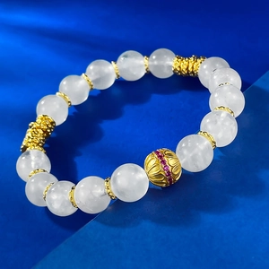 Macro shot of S925 silver moonstone bracelet with filigree gold beads and red gemstone
