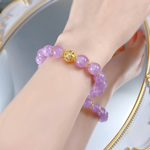 Detail of 10mm lavender amethyst bracelet with gold hollow bead and floral spacers