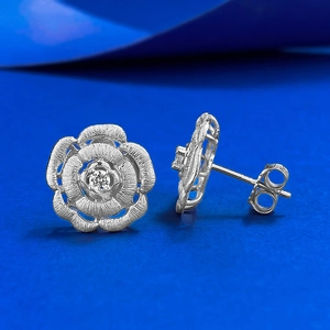Macro detail of brushed S925 silver camellia stud earrings with a central zircon stone