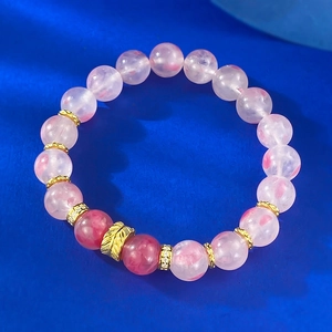 Detail view of 9mm translucent pink cherry blossom crystal beads with golden leaf charm