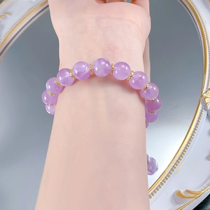 Elegant 10mm lavender amethyst bead bracelet on wrist with gold floral spacers