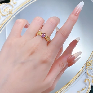 Close-up of vintage lace style gold ring with oval purple amethyst and white zircon stones