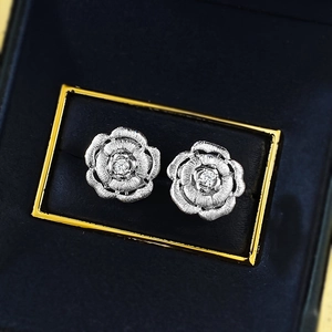 Elegant silver camellia stud earrings with brushed texture and zircon center in box