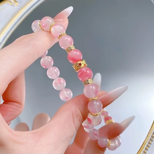 Close-up of 9mm pink crystal bead bracelet with gold spacer charms on a model's wrist