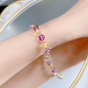 Détail du bracelet en cristal d'améthyste et citrine facetté avec des disques dorés