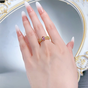 Macro shot of retro gold S925 silver lace ring with oval violet gemstone and carving