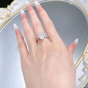 Macro shot of an oval-cut gemstone ring on a finger with a vintage mirror reflection