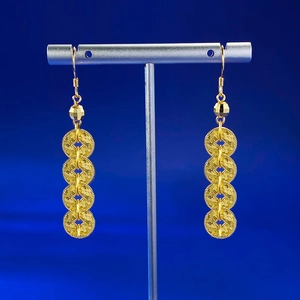 Close-up of gold coin drop earrings with CNC textured rings and elegant hook design