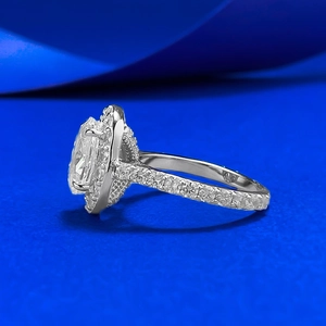 Elegant 7x10mm oval halo diamond ring with shimmering stones on a vibrant blue backdrop