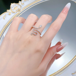 Macro shot of silver snake ring with sparkling zircons and pear-cut head stone on hand