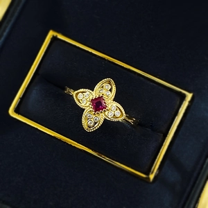 S925 silver four-leaf clover ring with red gemstone in gold finish on velvet box