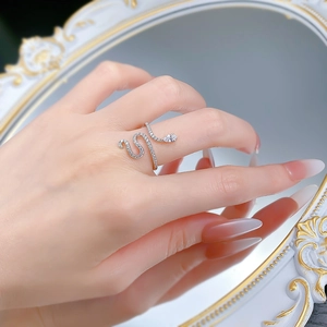 Macro detail of a silver snake-shaped ring with pavé crystals on a vintage mirror surface