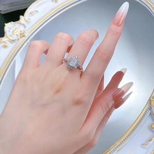 Macro shot of silver sterling ring with emerald cut white diamond on hand mirror background