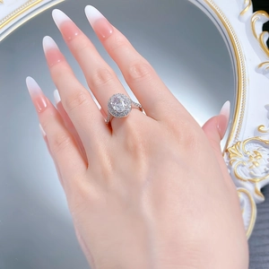 Detailed close-up of oval cut halo cubic zirconia wedding ring on a model hand