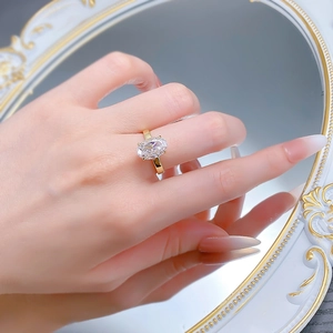 Gros plan d'une bague dorée taille ovale effet glace se reflétant dans un miroir chic