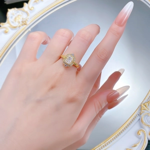 Macro shot of 18K gold ring featuring a rectangle cut sparkling diamond on a model finger