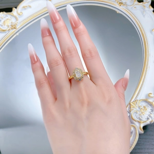 Macro view of gold plated engagement ring with ice-cut cubic zirconia on a hand