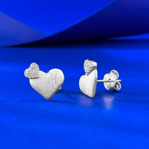 Boucles d'oreilles cœur en argent sterling S925 avec finition brossée sur fond bleu