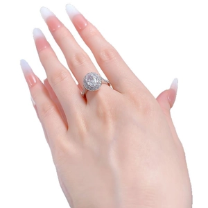 Luxe halo oval cut diamond engagement ring set on model hand with pavé band