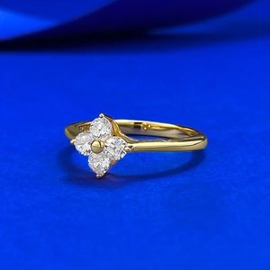 Macro view of gold flower ring featuring four clear petal-shaped cubic zirconia stones