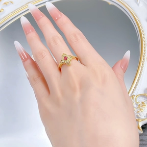Detail of s925 silver four-leaf clover ring with red gemstone and diamonds on model