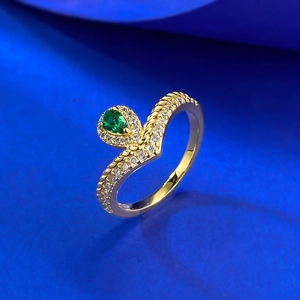 Elegant gold V-shaped ring featuring a pear-cut emerald stone and pavé white diamonds