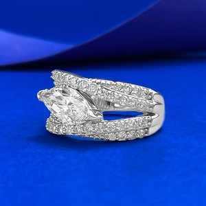 Marquise-cut diamond silver ring with pavé-set bands on a deep blue background