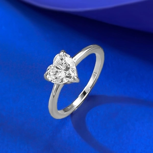 Bague élégante avec solitaire taille cœur 7x7mm sur fond de satin bleu luxueux