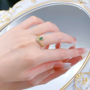 Detail of V-shaped gold plated ring with pear-cut emerald green stone and zircon inlay
