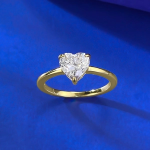 Macro detail of heart-cut diamond ring showing 925 sterling silver stamp on gold band