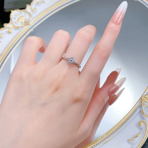 Macro shot of silver four-leaf clover ring with delicate micro-diamond inlays on hand