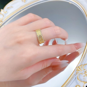 Détail d'une bague large ajourée plaquée or avec strass et style de pièce de monnaie rétro