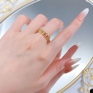 Detail eines vergoldeten Vintage-Rings mit filigranem Muster und roten Edelsteinen