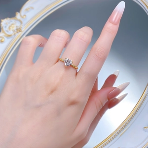 Close-up of elegant S925 silver heart diamond ring in gold finish on a woman's hand