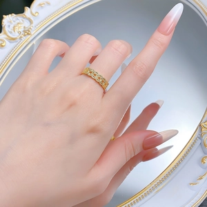 Detail of vintage gold-plated hollow coin ring shown on model against retro mirror