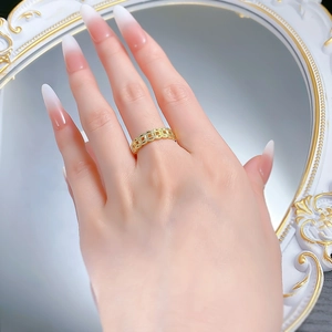 Close-up of a gold-plated coin ring with ancient Chinese money patterns on a hand