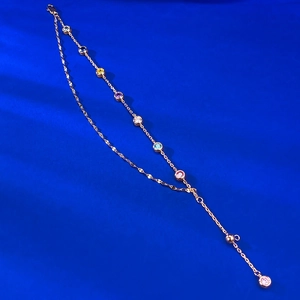 Detailed view of double-layer rose gold chain with eight multi-colored round gemstones