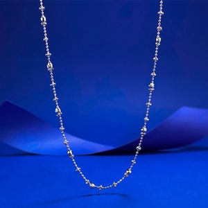 S925 sterling silver necklace with beads and flower charms on a deep blue background