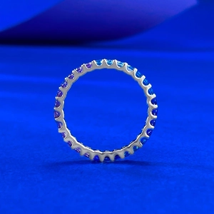 Macro detail of S925 silver eternity ring with lavender gradient gemstones in velvet set