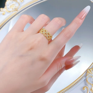 Détail d'une bague tressée dorée ornée de zircons blancs sur la main d'un mannequin